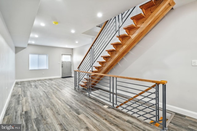 staircase with recessed lighting, wood finished floors, and baseboards