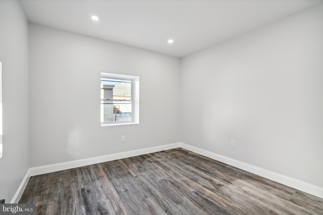 spare room featuring recessed lighting, wood finished floors, and baseboards