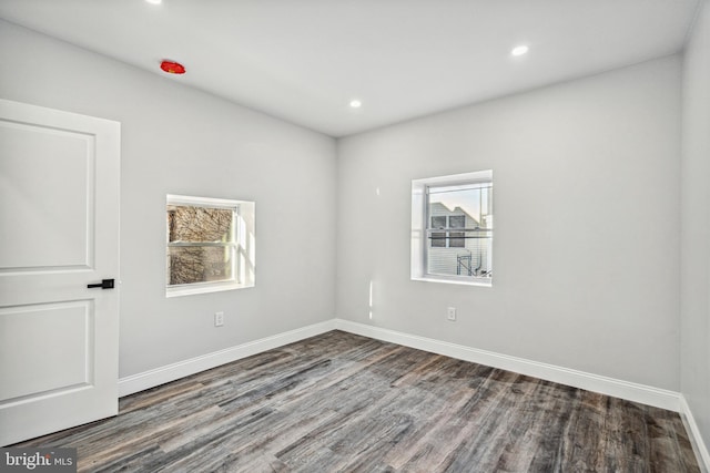 empty room with recessed lighting, baseboards, and wood finished floors