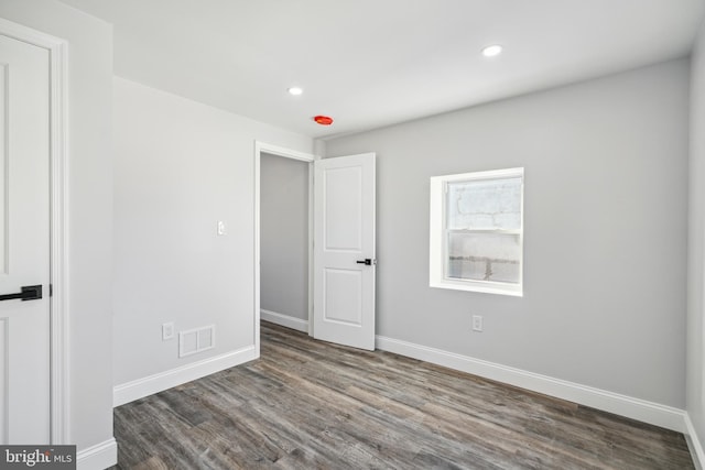 unfurnished bedroom with visible vents, baseboards, and wood finished floors