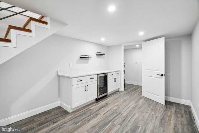 kitchen with wine cooler, light countertops, baseboards, and wood finished floors