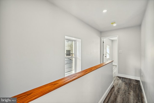 hall with an upstairs landing, recessed lighting, dark wood-type flooring, and baseboards