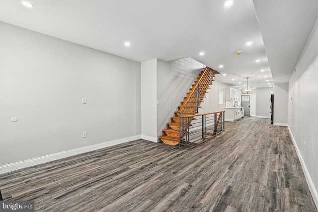 below grade area with recessed lighting, dark wood-type flooring, and freestanding refrigerator