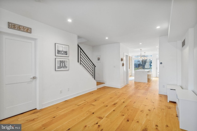 interior space with visible vents, stairway, light wood-type flooring, recessed lighting, and an inviting chandelier