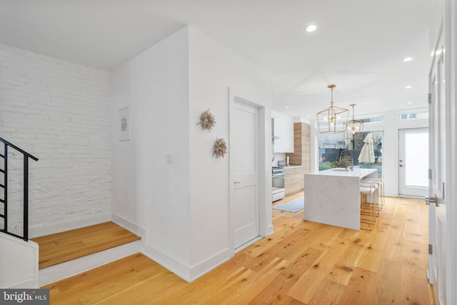 interior space with recessed lighting, baseboards, a notable chandelier, and light wood-style flooring