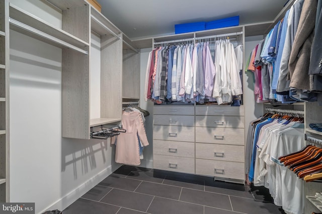 walk in closet with dark tile patterned floors