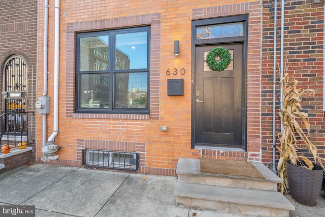 doorway to property with brick siding