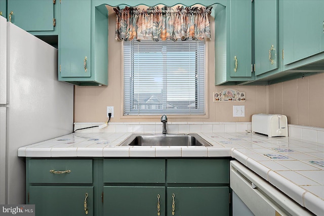 kitchen featuring a sink, white appliances, and light countertops