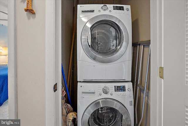 clothes washing area with laundry area and stacked washing maching and dryer