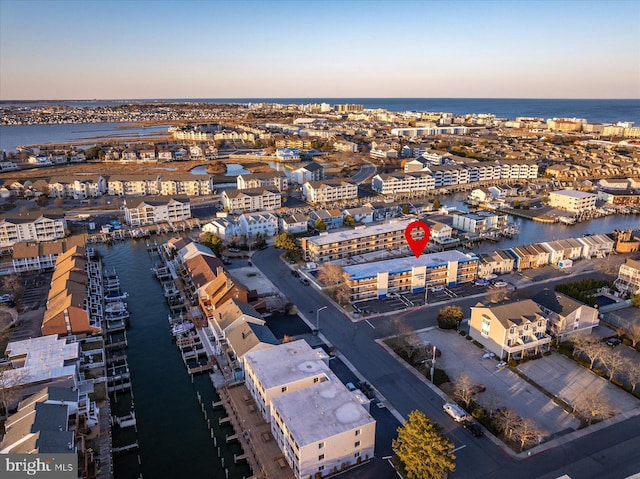 aerial view at dusk featuring a water view