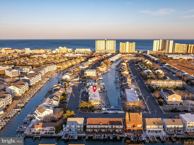 aerial view at dusk featuring a water view