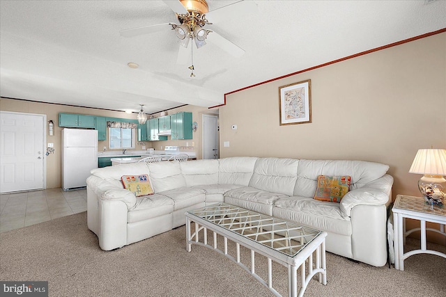 living area with ornamental molding, light carpet, light tile patterned flooring, a textured ceiling, and a ceiling fan