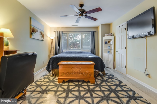 bedroom with visible vents, baseboards, light wood-style flooring, and a ceiling fan