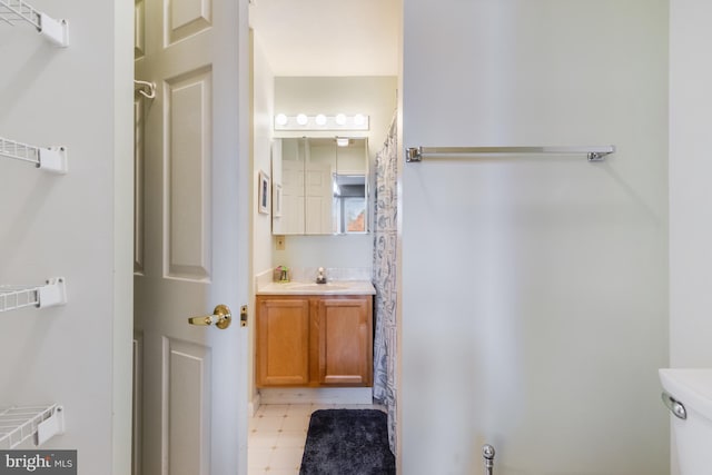 full bath with tile patterned floors, curtained shower, toilet, and vanity