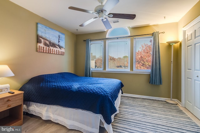 bedroom featuring wood finished floors, visible vents, baseboards, and ceiling fan