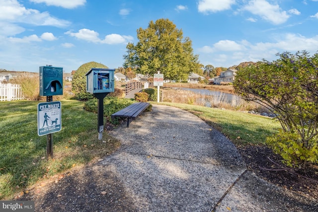 view of property's community featuring a yard and a water view