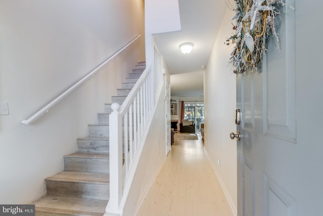 foyer with stairs, baseboards, and light wood-type flooring