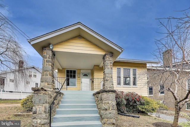 view of front of home with a porch and fence