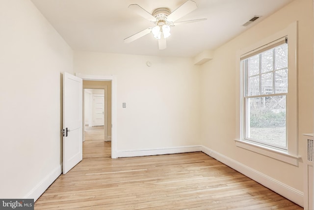 unfurnished room featuring light wood-type flooring, visible vents, baseboards, and ceiling fan