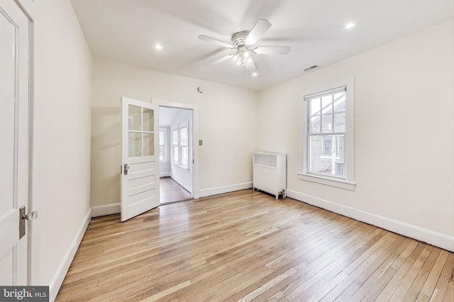 unfurnished room featuring a ceiling fan, baseboards, light wood-style flooring, radiator heating unit, and recessed lighting