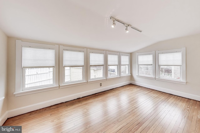 unfurnished sunroom featuring track lighting and lofted ceiling