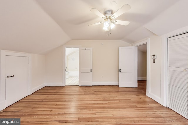 bonus room featuring baseboards, lofted ceiling, light wood-style floors, and a ceiling fan