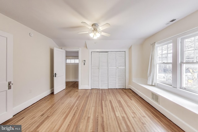 unfurnished bedroom featuring light wood-style flooring, baseboards, visible vents, and a closet