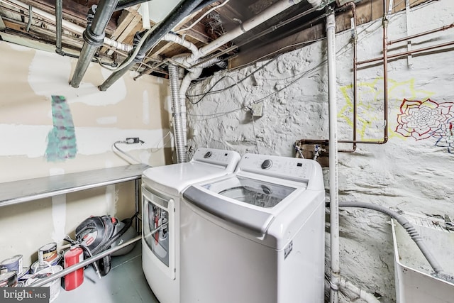 clothes washing area with separate washer and dryer and laundry area