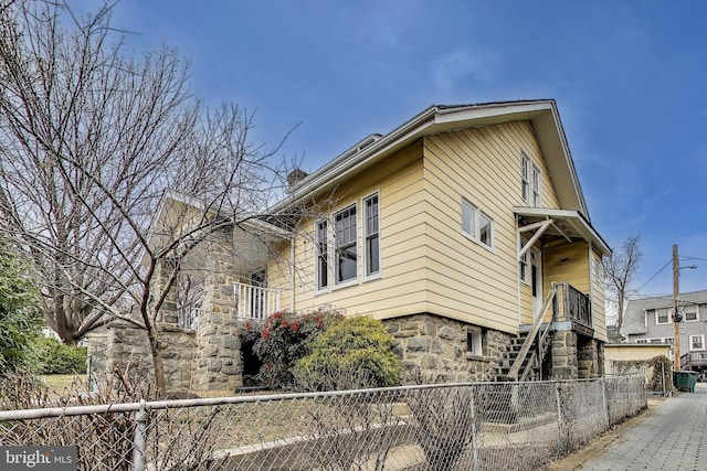 view of front facade featuring stairway and a fenced front yard