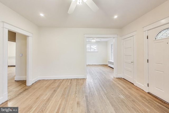 entryway with radiator heating unit, baseboards, light wood-type flooring, and ceiling fan