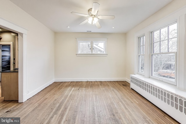 unfurnished room featuring baseboards, radiator heating unit, recessed lighting, hardwood / wood-style flooring, and a ceiling fan