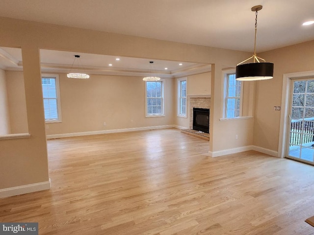 240 Banyan Dr, State College, PA 16801 - unfurnished living room featuring a fireplace, baseboards, a tray ceiling, and light wood-type flooring