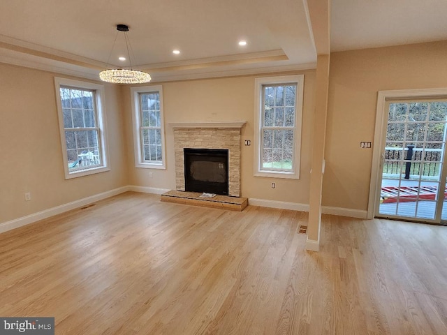 240 Banyan Dr, State College, PA 16801 - unfurnished living room featuring baseboards, a tray ceiling, light wood-style floors, and a healthy amount of sunlight
