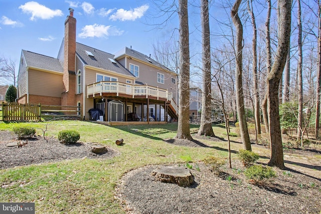 rear view of property featuring stairway, fence, a wooden deck, a yard, and a chimney