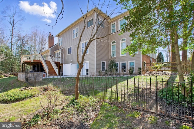 view of home's exterior featuring a chimney, stairway, a wooden deck, and fence