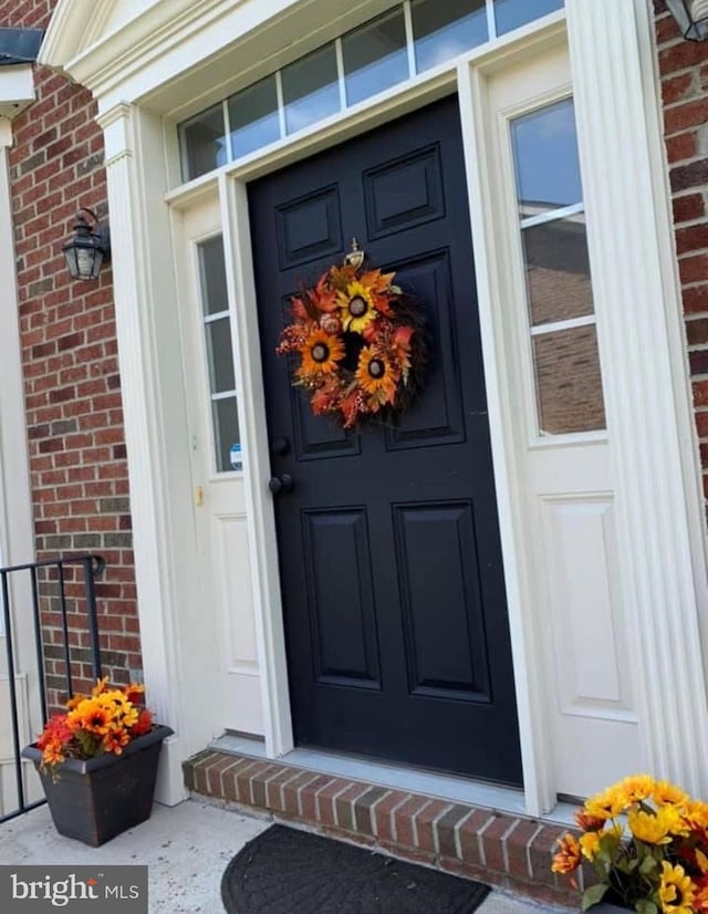 doorway to property featuring brick siding