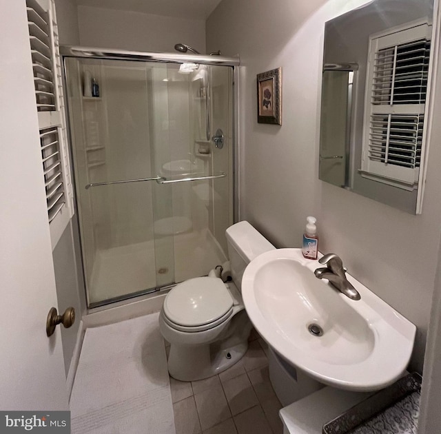 bathroom with tile patterned flooring, a shower stall, toilet, and a sink