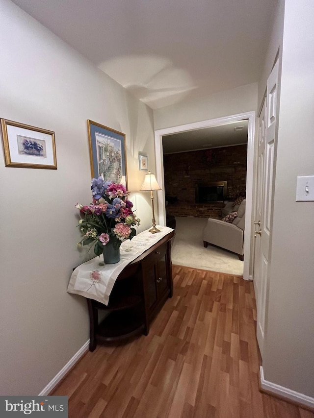 hallway featuring wood finished floors and baseboards