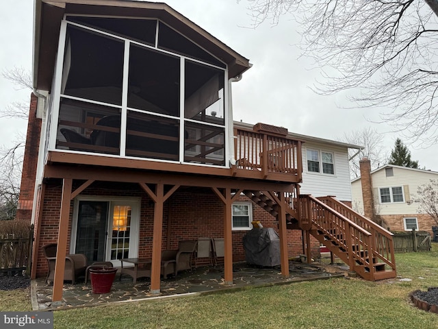 back of property with a sunroom, a wooden deck, brick siding, stairs, and a patio area