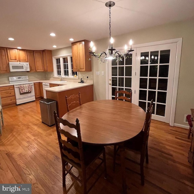 dining area featuring light wood-style flooring, a notable chandelier, and recessed lighting