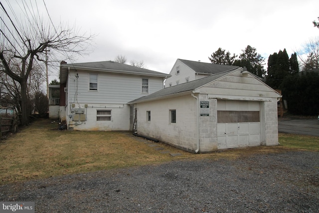 115 Crestmont Ave, State College, PA 16801 - view of side of property with gravel driveway, an attached garage, and a lawn