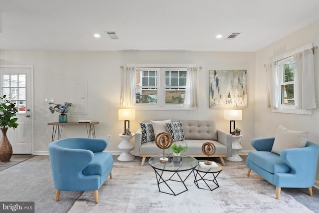 living area featuring recessed lighting, visible vents, and baseboards