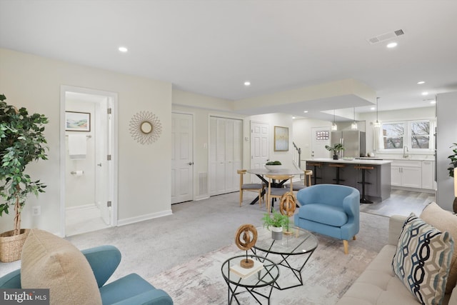 living area with visible vents, recessed lighting, and baseboards