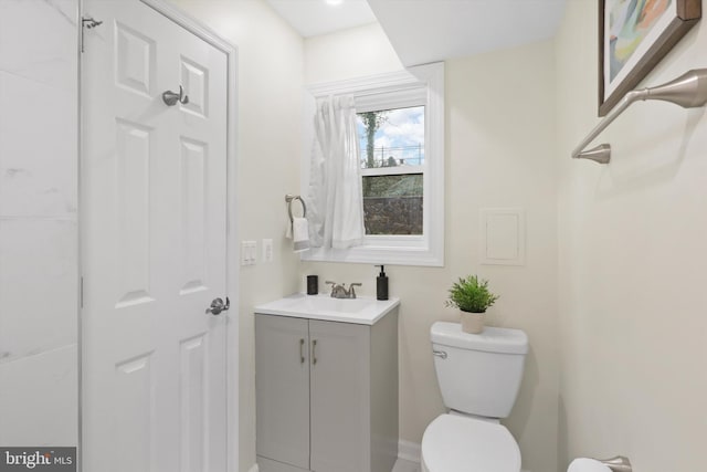 half bathroom featuring vanity and toilet