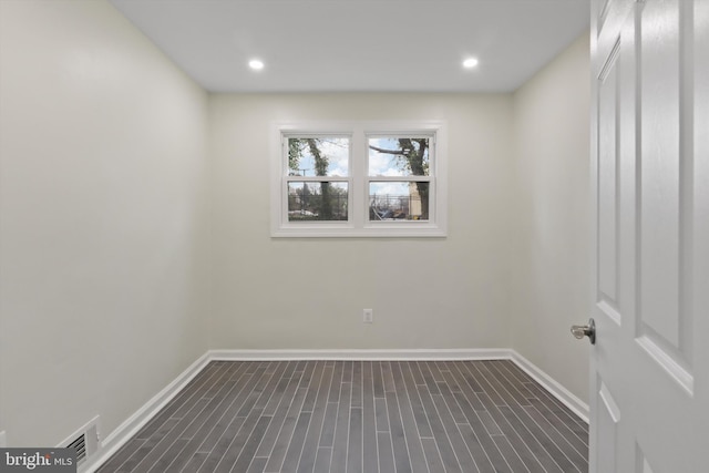 empty room with recessed lighting, visible vents, baseboards, and dark wood-type flooring