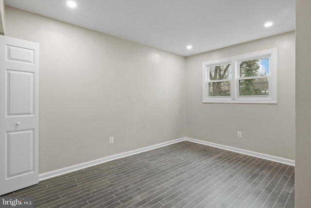 empty room featuring dark wood finished floors, recessed lighting, and baseboards