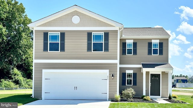 view of front facade featuring a garage, concrete driveway, and a front yard