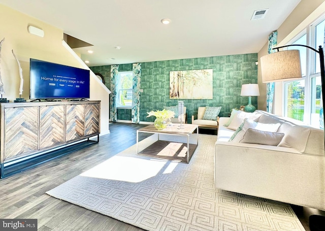 living room with recessed lighting, visible vents, wood finished floors, and wallpapered walls