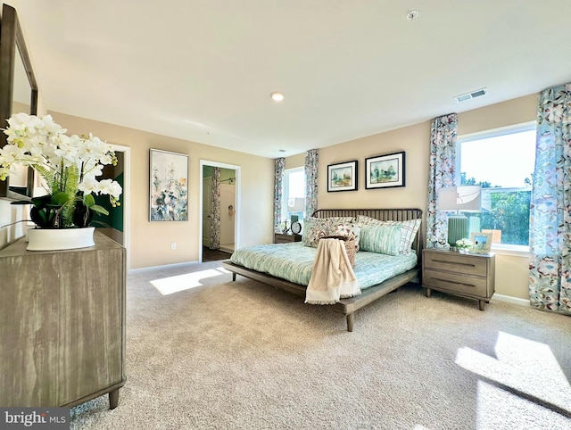 carpeted bedroom with visible vents and baseboards