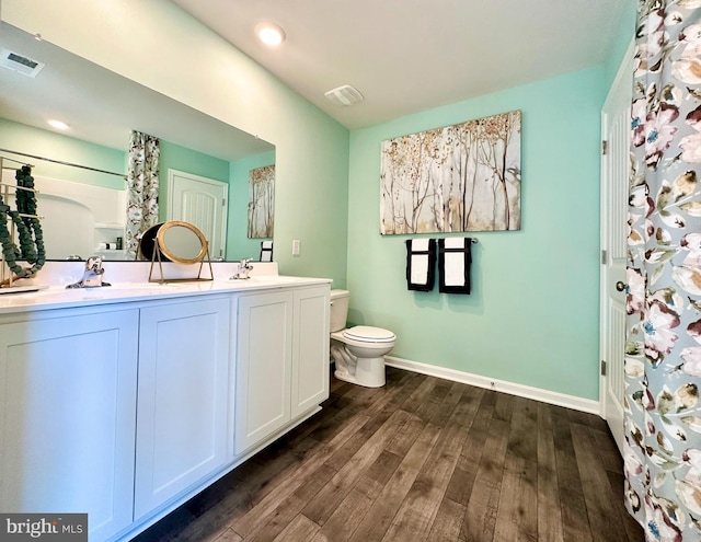 full bathroom featuring visible vents, baseboards, toilet, and wood finished floors